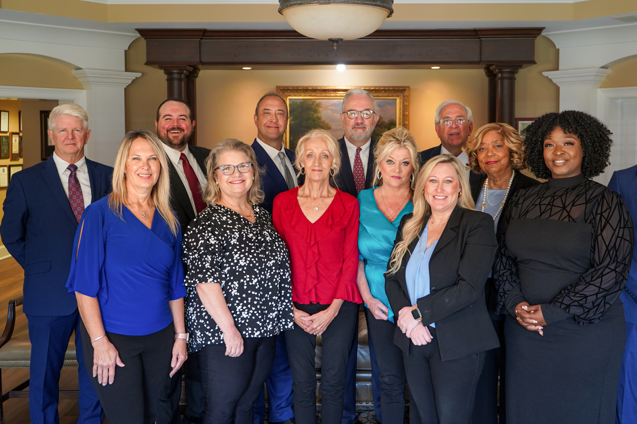 The attorneys and staff at the Personal Injury Law Firm of Conchin Cole Jordan & Sherrod pose for a group photo standing up in their office in Huntsville Alabama.
