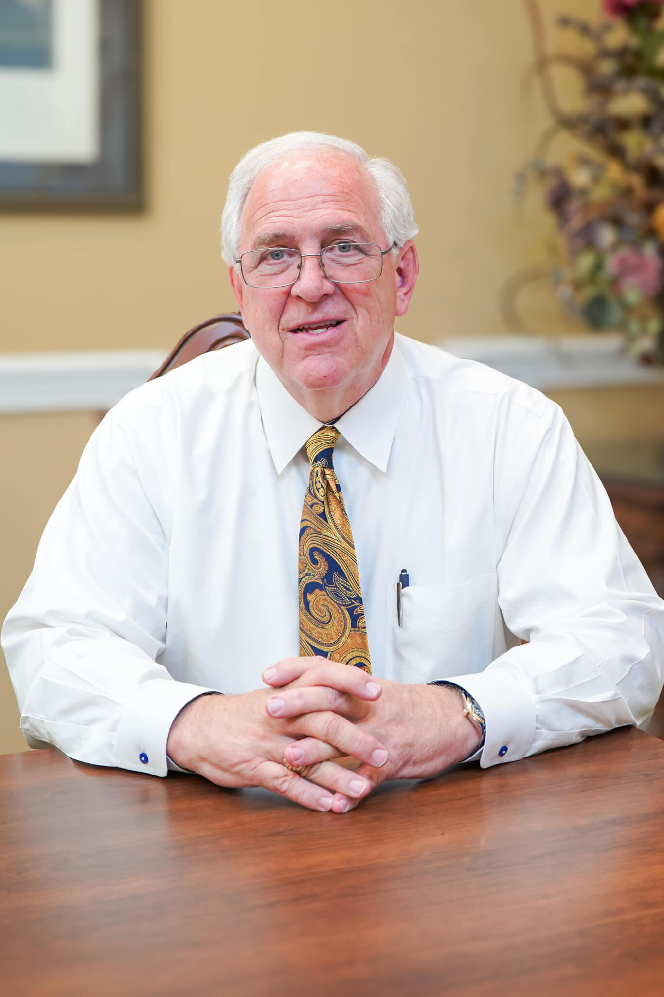 CCJS founding partner and attorney with decades of experience, Gary Conchin smiles for a photo sitting at a conference table at their office in Huntsville, Alabama