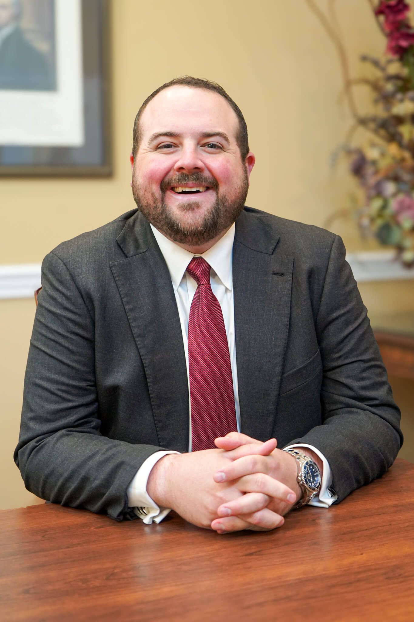 Personal injury attorney Andrew Banks sits at a conference table for a headshot where he is smiling.