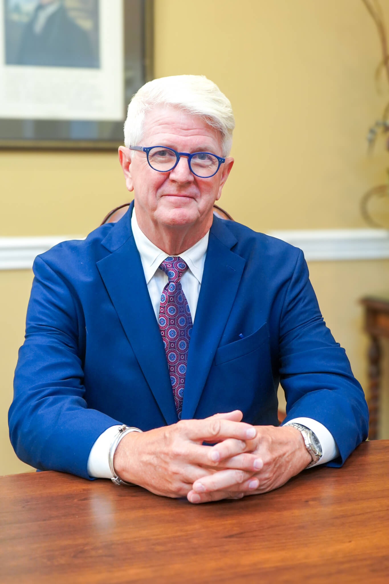 Attorney Patrick Lamar smiles softly for a photo at a table in his personal injury law office in Huntsville, Alabama